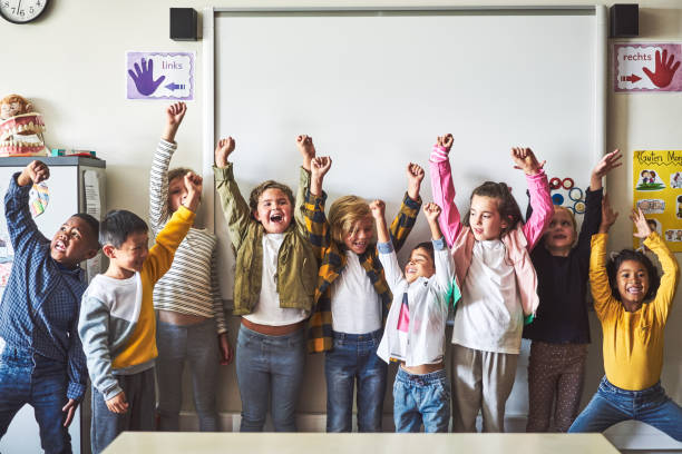 istock Happy students with arms raised enjoying in school 1224088323