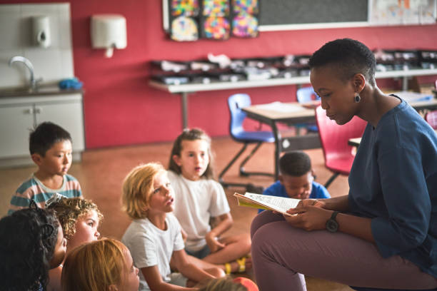 istock Teacher reading book to students in classroom 1224088331