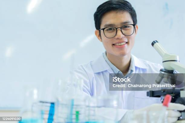 Stock fotografie Zblízka Mladý Asijský Vědec Pomocí Mikroskopu K Výzkumu Nebo Záznamu A Analýze Výsledků Vědeckého Experimentu S Virovými Buňkmi V Laboratoři Pro Zdravotní Péči A Farmaceutický Koncept – stáhnout obrázek nyní