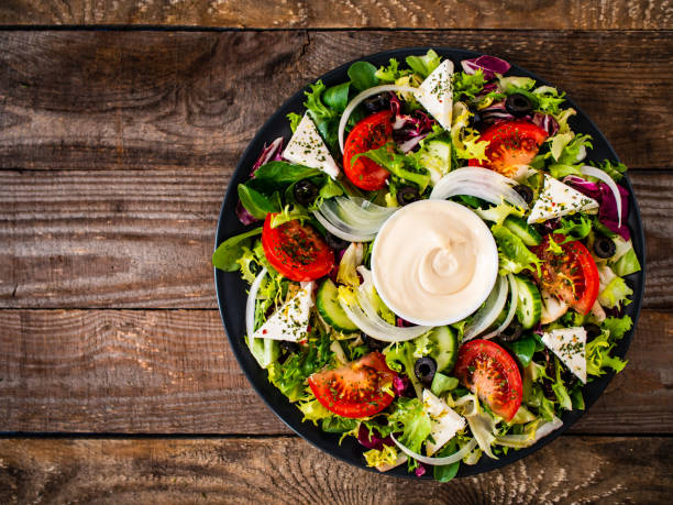 griechischer salat auf holztisch - mayonnaise stock-fotos und bilder