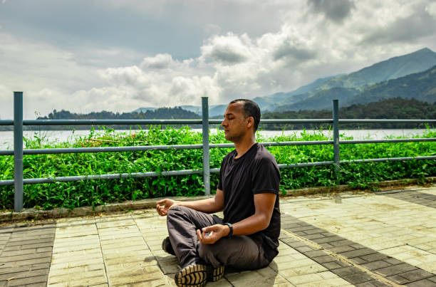 istock man meditating at beautiful lake hiking trails with mountain background from unique perspective 1224098029