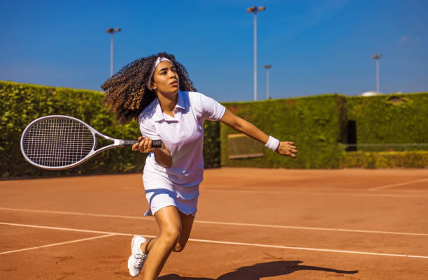 eine schöne schwarze tennisspielerin auf dem platz - tennis stock-fotos und bilder