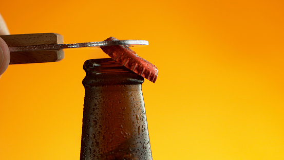 Opening of beer cap with the gas output, macro shot in detail.