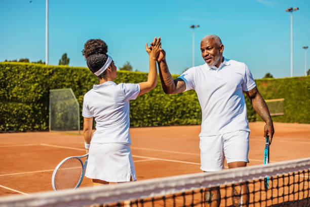 eine schöne schwarze tennisspielerin auf dem platz mit ihrem trainervater - country club fotos stock-fotos und bilder