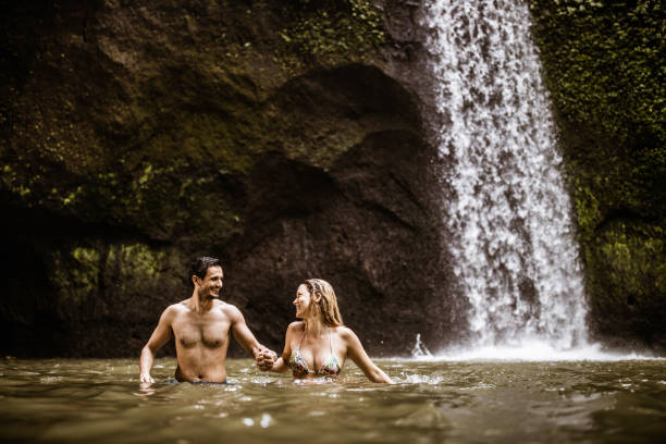 istock Young carefree couple going trough water in rainforest. 1224103802