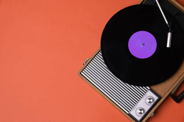 Vintage vinyl player and turnable on a orange background. Entertainment 70s. Listen to music. Top view.