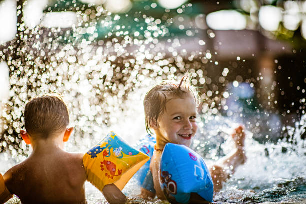 istock Little boys having fun while splashing water in summer day. 1224106149