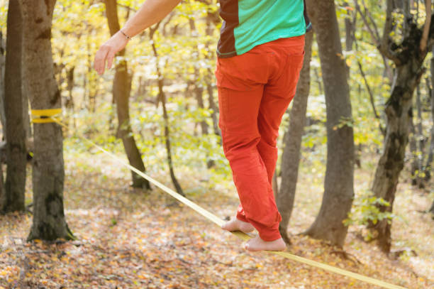 istock A bearded man in return is developing balance while walking along the slackline in the autumn forest on a sunny day. The concept of age leisure outdoors. 1224106190