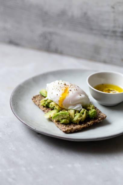 tasty sandwich with poached egg and avocado on mrble background with copy space - poached egg imagens e fotografias de stock