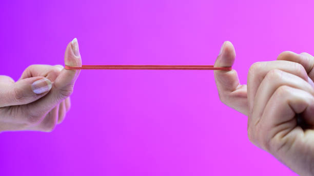 istock Man and woman stretching rubber band 1224106757