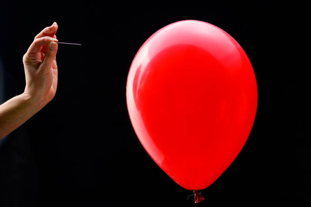 istock Woman's hand about to pop balloon 1224106783
