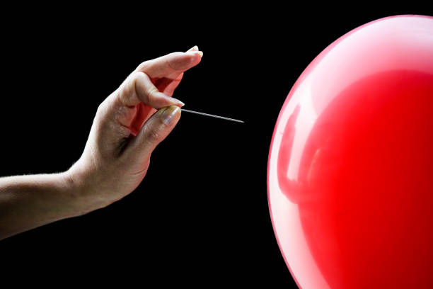 istock Woman's hand about to pop balloon 1224107853