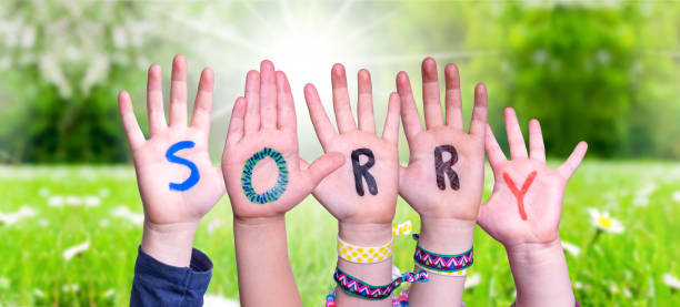 istock Children Hands Building Word Sorry, Grass Meadow 1224110175