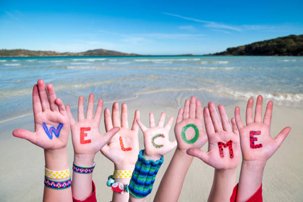 istock Children Hands Building Word Welcome, Ocean Background 1224111668
