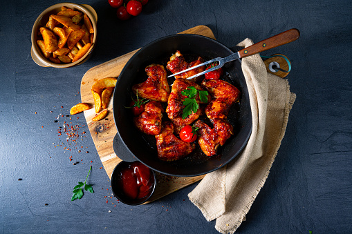 Spicy chicken wings in honey with potato wedges