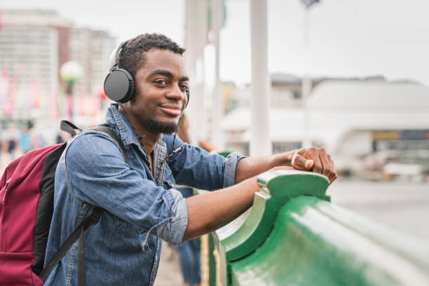 backpacker listening to music at darling harbor bridge sydney - darling harbor imagens e fotografias de stock