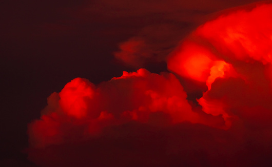Red clouds with dark sunset sky. Red bloody clouds on dark sky. Evening twilight sky. Nature background for summer season. Dramatic red sky. Hell or heaven background. Beauty and magic in nature.