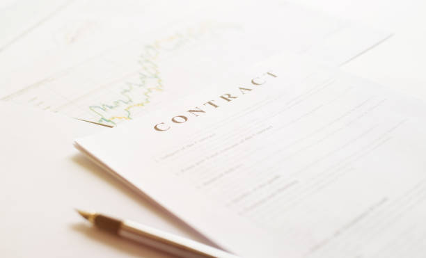 istock Contract paper and pen on white desk background. Focus on title Contract. Defocused pencil. 1224118896