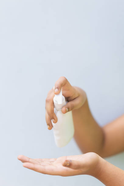 istock Child's hand with disinfectant hand sanitizer against plain background 1224119772