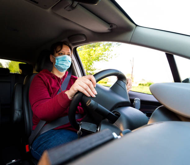 istock Female car driver wearing protective face mask while driving 1224123227