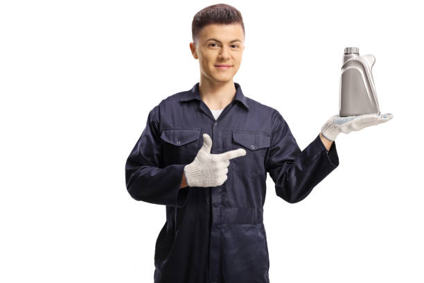 istock Young mechanic holding a motor oil bottle and pointing 1224123290