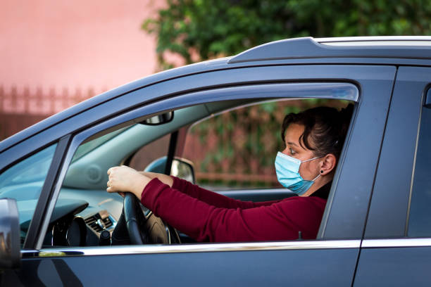 istock Female car driver wearing protective face mask while driving 1224123315