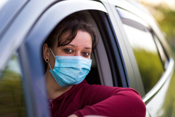 istock Female car driver wearing protective face mask while driving 1224123462