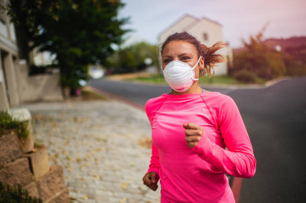 istock Young woman running with face mask 1224125751