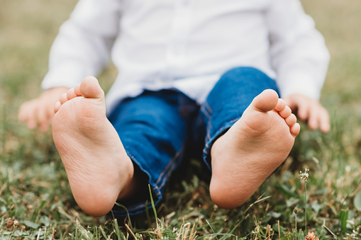 barebood baby feet on a grass healthy walk development