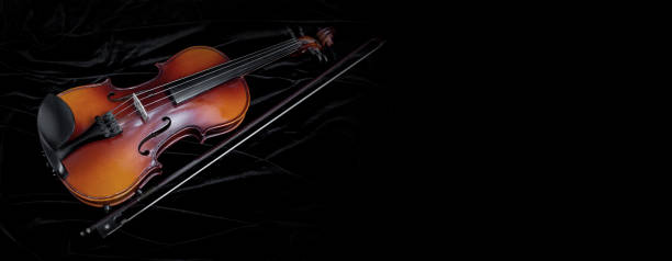 istock Shiny violin and bow isolated on black velvet  background 1224126963