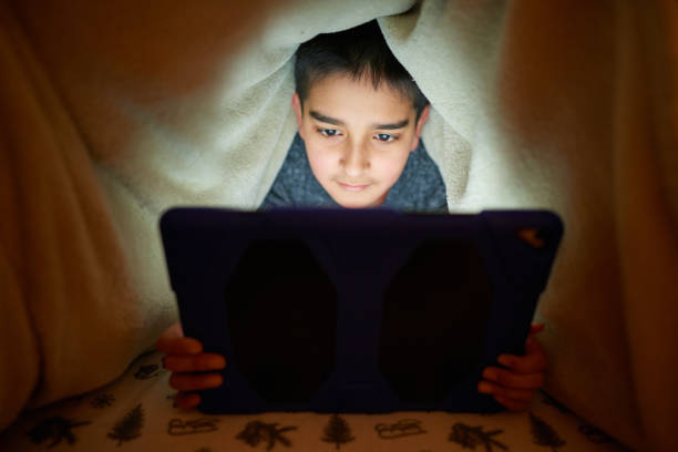 istock Boy watching cartoons at night 1224128462