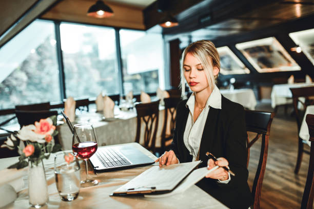 istock Elegant Female Working While Enjoying Wine In Restaurant 1224128847
