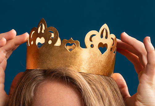 Young blond woman wearing gold crown on  head