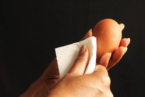 istock Close up hands cleaning dirty egg 1224130110