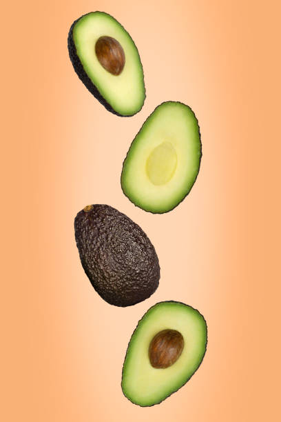istock Falling brown avocado isolated on a colored background with clipping path as package design element and advertising. 1224130605