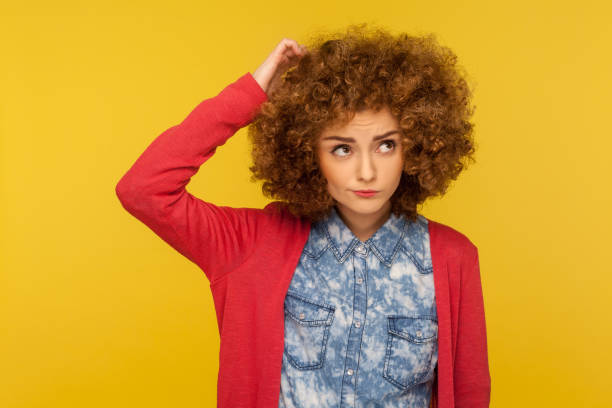 deep in thoughts. portrait of pensive confused woman with curly hair in casual outfit scratching head, wondering - pensive question mark teenager adversity imagens e fotografias de stock