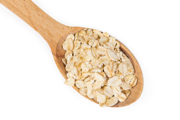istock Uncooked rolled oats in wooden spoon on a white background 1224131889