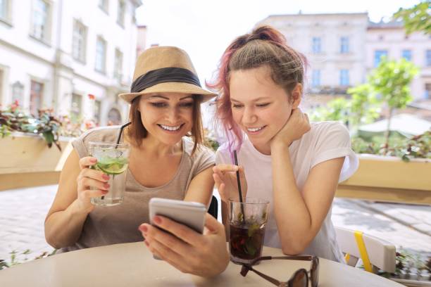 istock Talking and drinking soft drinks mother daughter teenager 1224131905