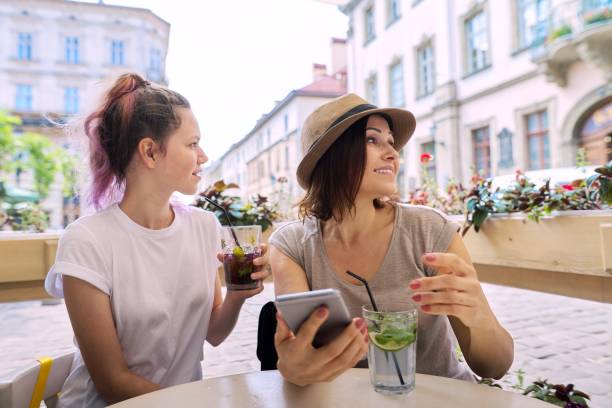 istock Talking and drinking soft drinks mother daughter teenager 1224131922