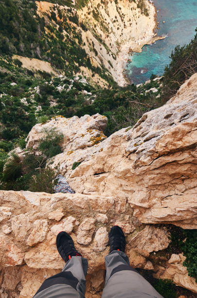 istock Unrecognizable man stands on the edge of cliff 1224133900