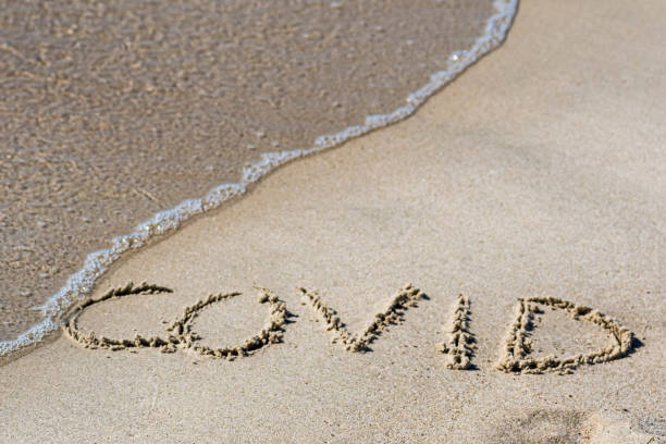 istock Covid written on the sand of a beach 1224135432