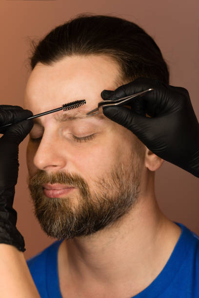 istock Correcting shape of eyebrows to male client 1224135687