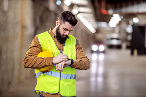 istock Young attractive contractor in working wear standing in underground garage in construction process and calling investors over smart watch. 1224136739