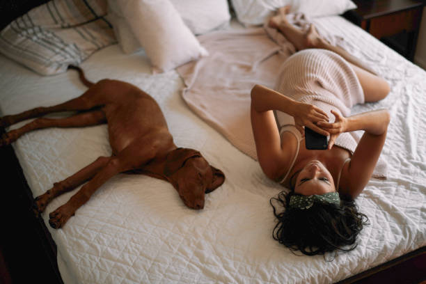 istock Beautiful girl lying on bed with dog. 1224136917