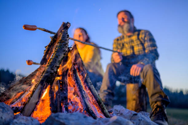 istock Mature couple roasting sausage over campfire 1224137116