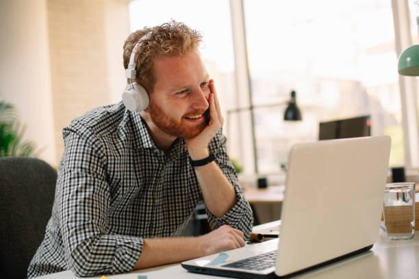 istock Young businessman listening music while working in office. 1224138534