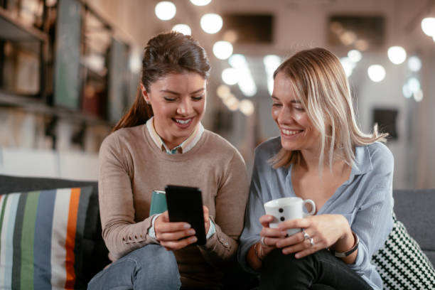 istock Two beautiful girlfriends drinking coffee in office. 1224138692