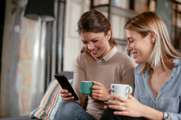 istock Two beautiful girlfriends drinking coffee in office. 1224138718