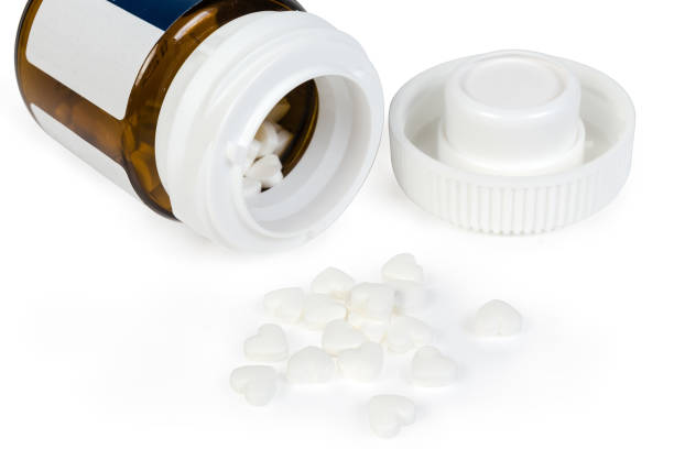 istock White heart shaped pills and glass pill container 1224140463
