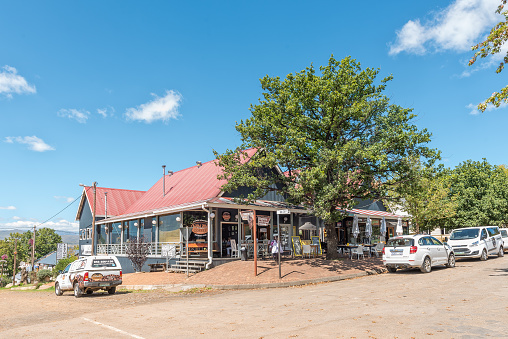 Clarens, South Africa - March 18, 2020:  A street scene, with a restaurant and vehicles, in Clarens in the Free State Province